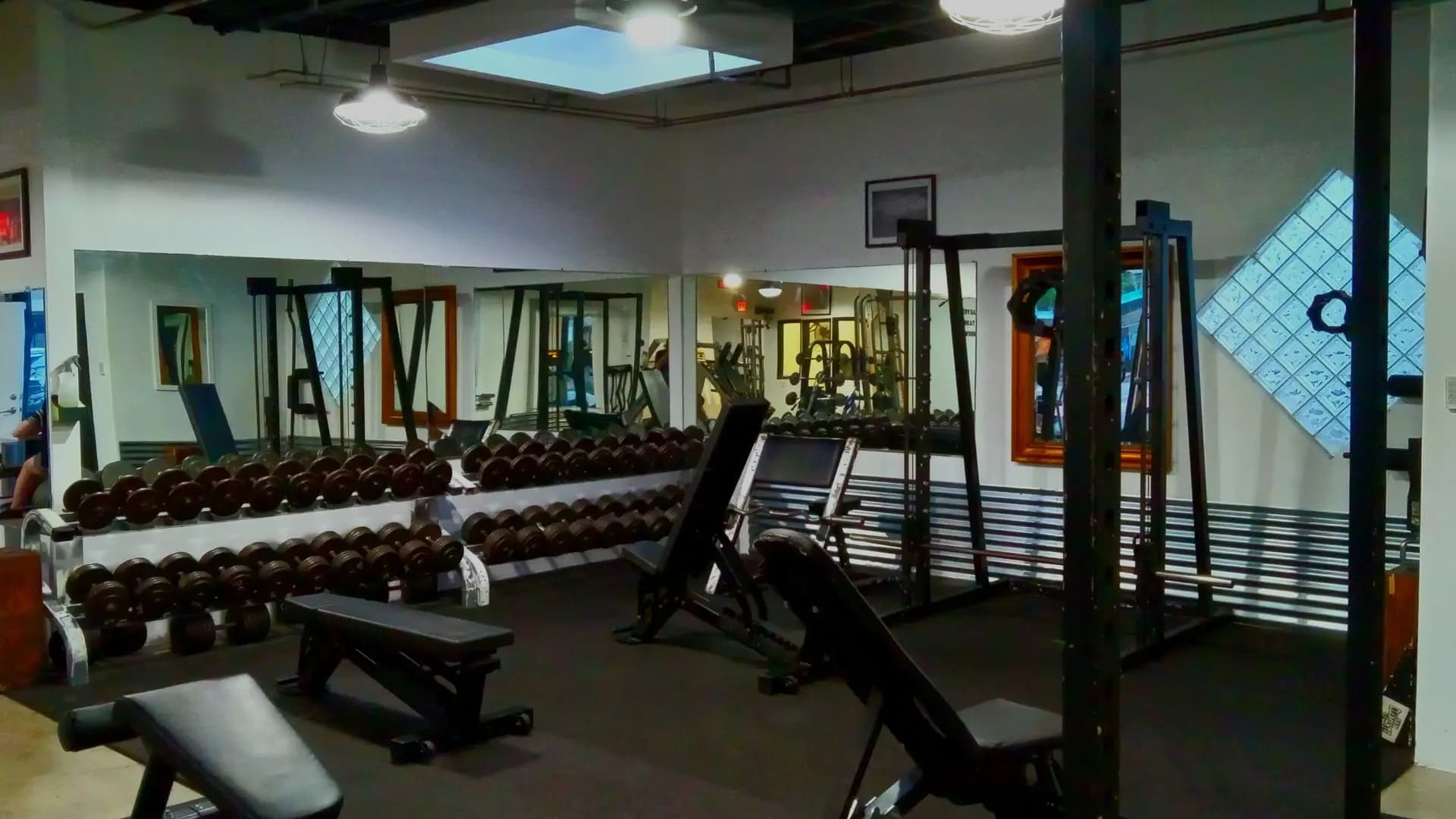 A heavy power rack and plate-loaded weights inside an old-school gym
